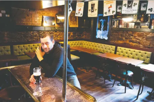  ?? ALLEN MCINNIS ?? With no St. Patrick’s parade and a closed bar, manager Rod Applebee sits alone at Hurley’s Irish Pub in Montreal on Tuesday.