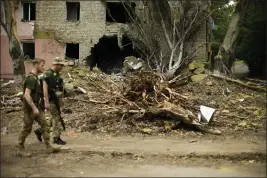  ?? FRANCISCO SECO — THE ASSOCIATED PRESS ?? Ukrainian servicemen walk past a damaged building in Bakhmut, eastern Ukraine, on Saturday.