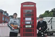  ??  ?? Musicians Calum and Finlay McLuckie played next to the red phone box at The Rockfield Centre.