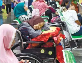  ?? /AP PHOTO ?? WAITING. A patient takes a nap on her wheelchair as she waits with others at the registrati­on desk at Dharmais Cancer Hospital in Jakarta, Indonesia. Global cyber chaos was spreading Monday as companies booted up computers at work following the...