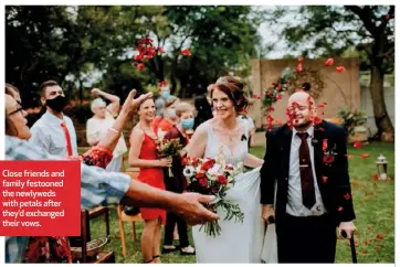  ??  ?? Close friends and family festooned the newlyweds with petals after they’d exchanged their vows.