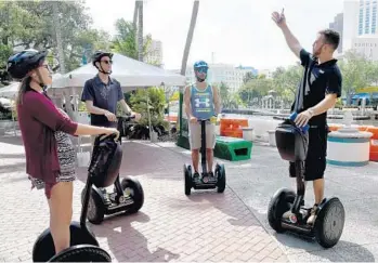  ?? TAIMY ALVAREZ/STAFF PHOTOGRAPH­ER ?? Jonathan Rosen, right, owner of Segway Fort Lauderdale, leads a group through downtown Fort Lauderdale. Riders are, from left, Carly Baldwin, of Sunrise, David Lombardo, of Hallandale Beach, and Adam Sanchez, of Miramar.