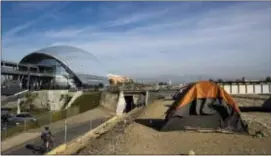  ?? JAE C. HONG — THE ASSOCIATED PRESS ?? Homeless tents are pitched on the Santa Ana River trail near the Anaheim Regional Transporta­tion Intermodal Center, a $185-million transporta­tion center, Saturday in Anaheim The number of homeless living in Orange County has climbed 8 percent over the...
