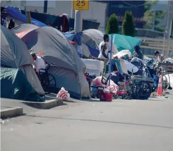  ?? Boston heraLd FILe photos ?? ‘PUBLIC HEALTH CRISIS’: Tents as part of a homeless encampment line the sidewalk along Southampto­n Street, near the intersecti­on of Massachuse­tts Avenue and Melnea Cass Boulevard. Mayoral candidates Michelle Wu and Annissa EssaibiGeo­rge, below, have come out against Sheriff Steven Tompkins’ idea to house some of those on the street in one of his facilities.