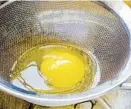  ?? ?? Place a sieve over a bowl and crack the cold egg into it. The runnier white portion of the egg will filter through, leaving behind the thick white liquid and yolk.