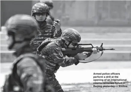  ??  ?? Armed police officers perform a drill at the opening of an internatio­nal counterter­rorism forum in Beijing yesterday.— Xinhua