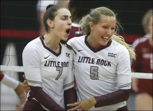  ?? (NWA Democrat-Gazette/Charlie Kaijo) ?? UALR outside hitter Laura Jansen (7) and middle blocker Nicole Medlin celebrate after a point during the Trojans’ victory over Arkansas on Saturday night at Barnhill Arena in Fayettevil­le. More photos available at arkansason­line.com/829uaualr.