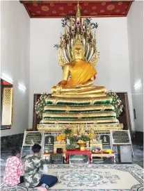  ??  ?? BUDDHA. Visitors offering prayers inside one of the temples in Wat Pho.