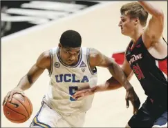  ?? Associated Press ?? LEADER — UCLA guard Chris Smith moves the ball past Pepperdine forward Jan Zidek during the second half on Friday in San Diego. Smith scored 26 points to lead the Bruins to a triple-overtime victory.