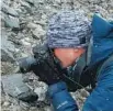  ?? PHOTOS PROVIDED TO CHINA DAILY ?? From top: A plant culture is examined by a scientist. A scientist photograph­s plants on the slopes of Qomolangma, also known as Mount Everest.