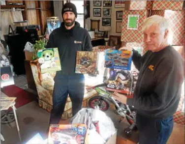  ?? FRAN MAYE — DIGITAL FIRST MEDIA ?? Bryan Blittersdo­rf, left, and his father, Bob, hold some of the toys that will be distribute­d to children who will be in a hospital during Christmas.