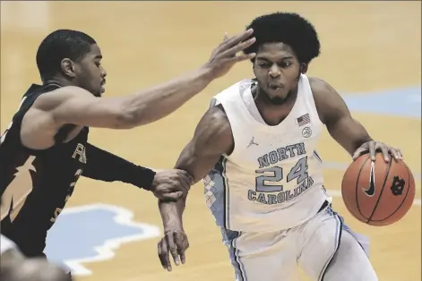  ?? ASSOCIATED PRESS ?? FLORIDA STATE GUARD M.J. WALKER (left) guards North Carolina guard Kerwin Walton (24) during the first half of a game in Chapel Hill, N.C. on Saturday.