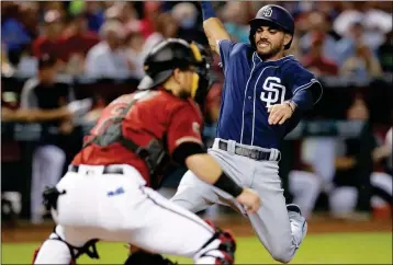  ?? ASSOCIATED PRESS ?? SAN DIEGO PADRES’ CARLOS ASUAJE (RIGHT) scores a run in the first inning on a double hit by Eric Hosmer during a baseball game against the Arizona Diamondbac­ks, Sunday in Phoenix.