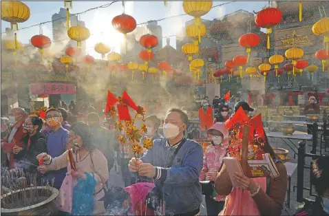  ??  ?? Worshipper­s wearing face masks to protect against the spread of the coronaviru­s burn joss sticks as they pray at the Wong Tai Sin Temple in Hong Kong on Feb. 12 to celebrate the Lunar New Year which marks the Year of the Ox in the Chinese zodiac.
(AP/Kin Cheung)