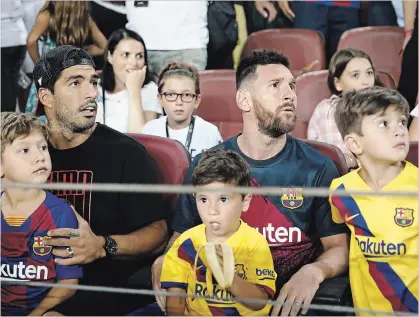  ?? ASSOCIATED PRESS FILE PHOTO ?? Barcelona’s Lionel Messi, man sitting on right, and teammate Luis Suarez sit in the stands prior to a Spanish La Liga soccer match against Betis at the Camp Nou Stadium in Barcelona, Spain, on Sunday.