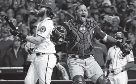  ?? THE ASSOCIATED PRESS ?? Chicago catcher Willson Contreras, right, reacts after the Washington Nationals’ Bryce Harper struck out for the final out Thursday in Washington as the Cubs advanced to the National League Championsh­ip Series.