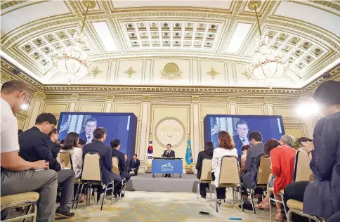  ?? — AFP photo ?? Moon (centre) speaks during a press conference marking his first 100 days in office at the presidenti­al house in Seoul.