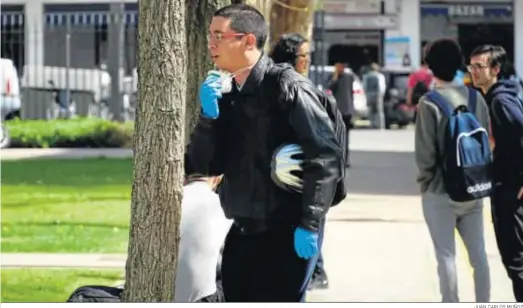  ?? JUAN CARLOS MUÑOZ ?? Un joven ataviado con guantes de latex y mascarilla en una zona universita­ria de Sevilla.