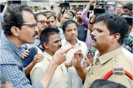  ??  ?? Left: Well-wishers argue with cops infront of Varavara’s house at Gandhinaga­r in the city. Top: Varavara’s wife Hemalatha (left) talking to the media