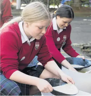  ?? PHOTO: GERARD O’BRIEN ?? Going for gold . . . Alice Barrett (left) and Alyssa Hitchcock, both year 10 pupils at Kaikorai Valley College, pan for gold during an outreach session at the University of Otago yesterday.