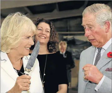  ?? Picture: REUTERS ?? SHARP WIT: Prince Charles nervously looks on as Camilla, Duchess of Cornwall, wields a knife during a visit to Seppeltsfi­eld Winery in South Australia's Barossa Valley