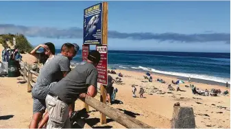  ?? Susan Haigh / Associated Press ?? People keep their distance Saturday after a reported shark attack at Newcomb Hollow Beach in Wellfleet, Mass. A man was attacked by a shark off Cape Cod and died later at a hospital.