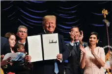  ?? NICHOLAS KAMM/AFP/GETTY IMAGES NORTH AMERICA ?? U.S. President Donald Trump holds up an executive order on Advancing American Kidney Health after delivering remarks Wednesday in Washington, D.C.