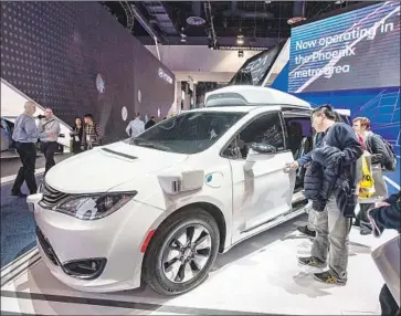  ?? David McNew AFP/Getty Images ?? A WAYMO driverless vehicle is displayed at last month’s CES convention in Las Vegas. Waymo, a division of Google parent Alphabet, has begun offering robot car taxi service around the Phoenix area.