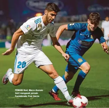  ??  ?? PEMAIN Real, Marco Asensio (kiri) mengasak pemain Fuenlabrad­a, Fran Garcia.