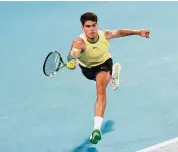  ?? Kelly Defina/Getty Images ?? Carlos Alcaraz plays a forehand in a first-round match against Richard Gasquet during the Australian Open at Melbourne Park on Tuesday.