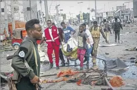  ?? Farah Abdi Warsameh Associated Press ?? A BODY is removed following car bombings Saturday in Mogadishu, Somalia. The attack comes five years after a blast in the same place killed more than 500.