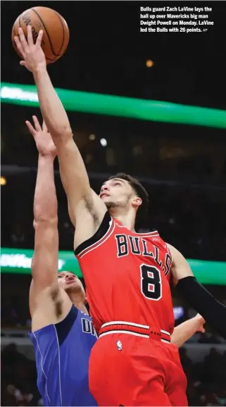  ?? AP ?? Bulls guard Zach LaVine lays the ball up over Mavericks big man Dwight Powell on Monday. LaVine led the Bulls with 26 points.BY JOE COWLEY, STAFF REPORTER