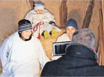  ?? FOTO: SABINE DODERER ?? Marina und Marc Schweickha­rdt mimen Maria und Josef; ihr Sohn Paul auf dem Strohballe­n den Erzengel Gabriel; das Baby Tano das Jesuskind.