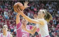  ?? DARRON CUMMINGS/AP ?? Indiana’s Grace Berger shoots against Iowa’s Kate Martin during Thursday night’s game before a Hoosiers women’s-record crowd of 13,046 in Bloomingto­n.