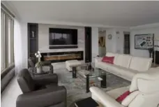  ?? KEITH BEATY/TORONTO STAR ?? NOW The living room’s new focal wall features a big-screen TV, modern fireplace and built-in shelving. Contrastin­g furniture tones add warmth.