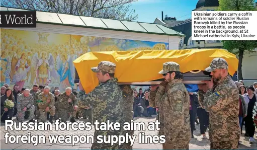  ?? ?? Ukrainian soldiers carry a coffin with remains of soldier Ruslan Borovyk killed by the Russian troops in a battle, as people kneel in the background, at St Michael cathedral in Kyiv, Ukraine