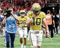  ?? PHOTOS BY HYOSUB SHIN/HYOSUB.SHIN@AJC.COM ?? Georgia Tech quarterbac­k Haynes King (center) leaves the field Friday after Louisville won the inaugural Aflac Kickoff Game at Mercedes-benz Stadium in Atlanta. “The second quarter we were on everything. We were on a roll,” King said. But the second half told a different story.