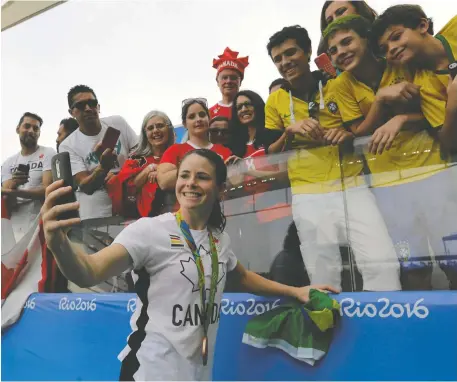  ?? THE ASSOCIATED PRESS FILES ?? Diana Matheson, shown taking a selfie with fans after a bronze-medal performanc­e for Canada at the 2016 Summer Olympics in Brazil, is helping lead the push for a new national women's soccer league. The hope is to have eight teams and to begin play in 2025.