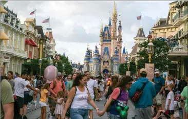  ?? TED SHAFFREY — THE ASSOCIATED PRESS ?? People visit Magic Kingdom Park at Walt Disney World Resort in Lake Buena Vista, Florida, in April. The Magic Kingdom is among the U.S. theme parks that have seen alarming fights among visitors and park employees recently.