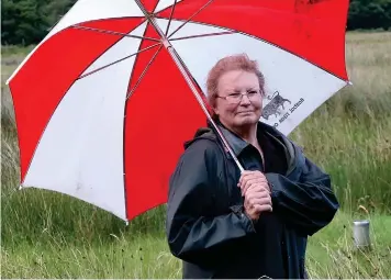  ??  ?? Drenched: Glenys Macmillan on her farm where the sheep are too wet to shear