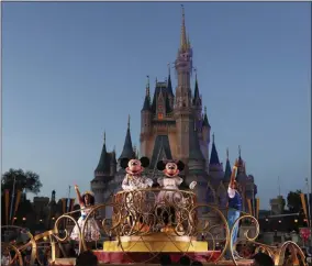  ?? JOHN RAOUX - ASSOCIATED PRESS ?? In this Jan. 15 file photo, Mickey and Minnie Mouse perform during a parade as they pass by the Cinderella Castle at the Magic Kingdom theme park at Walt Disney World in Lake Buena Vista, Fla.