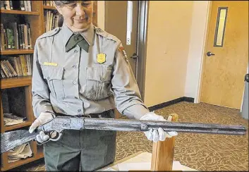  ?? Great Basin National Park ?? Archaeolog­ist Eva Jensen holds the Winchester rifle that she found leaning against a tree in Great Basin National Park.