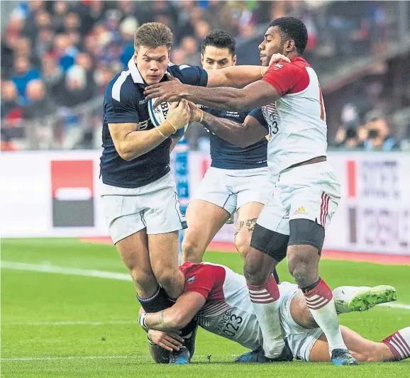  ?? Photograph: SNS ?? France try to get to grips with Huw Jones in Paris. The outside centre has made a significan­t difference to Scotland