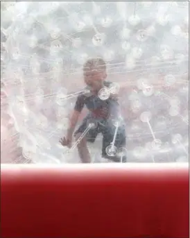  ?? JONATHAN TRESSLER — THE NEWS-HERALD ?? Seven-year-old Charlie Sivillo pushes his way along an inflatable course inside a big, inflatable ball during the first day of Mentor’s CityFest Aug. 24 while his dad, Ed, just off camera to the left, follows along on stable ground.