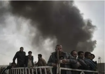  ?? FELIPE DANA/THE ASSOCIATED PRESS FILE PHOTO ?? Displaced people stand on the back of a truck at a checkpoint near Qayara, south of Mosul, late last year.