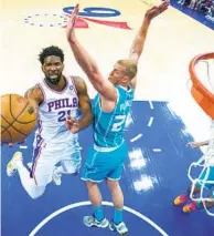  ?? CHRIS SZAGOLA AP ?? Philadelph­ia’s Joel Embiid (left) goes up for a shot as Charlotte’s Mason Plumlee in the 76ers’ victory Saturday night.