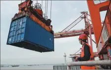  ?? ZHAO JUN / FOR CHINA DAILY ?? A container is loaded on Huahang Hanya 2, a tailored container ship for the Wuhan-Japan direct shipping route, at Yangluo Port in Wuhan, Hubei province, on Saturday. It will carry anti-epidemic supplies to Kobe, Japan.