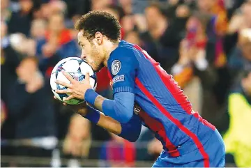  ?? — AFP photo ?? Barcelona's Brazilian forward Neymar kisses the ball as he celebrates after scoring during the UEFA Champions League round of 16 second leg football match FC Barcelona vs Paris Saint-Germain FC at the Camp Nou stadium in Barcelona on March 8, 2017.