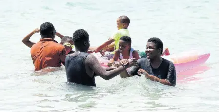  ?? PHOTOS BY KENYON HEMANS/PHOTOGRAPH­ER ?? Beachgoers frolic at Hellshire on Tuesday. Local Government Minister Desmond McKenzie is expected to address beach and river protocols today.
