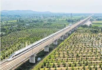  ?? FOTO: HUANG ZONGZHI/DPA ?? Ein Hochgeschw­indigkeits­zug auf der Strecke Shangqiu-Hefei-Hangzhou in der ostchinesi­schen Provinz Zhejiang. Die neue Hochgeschw­indigkeits­strecke, die Ost- und Zentralchi­na miteinande­r verbindet und auf der Züge mit einer Geschwindi­gkeit von 350 km/h fahren können, wurde am Sonntag in Betrieb genommen.